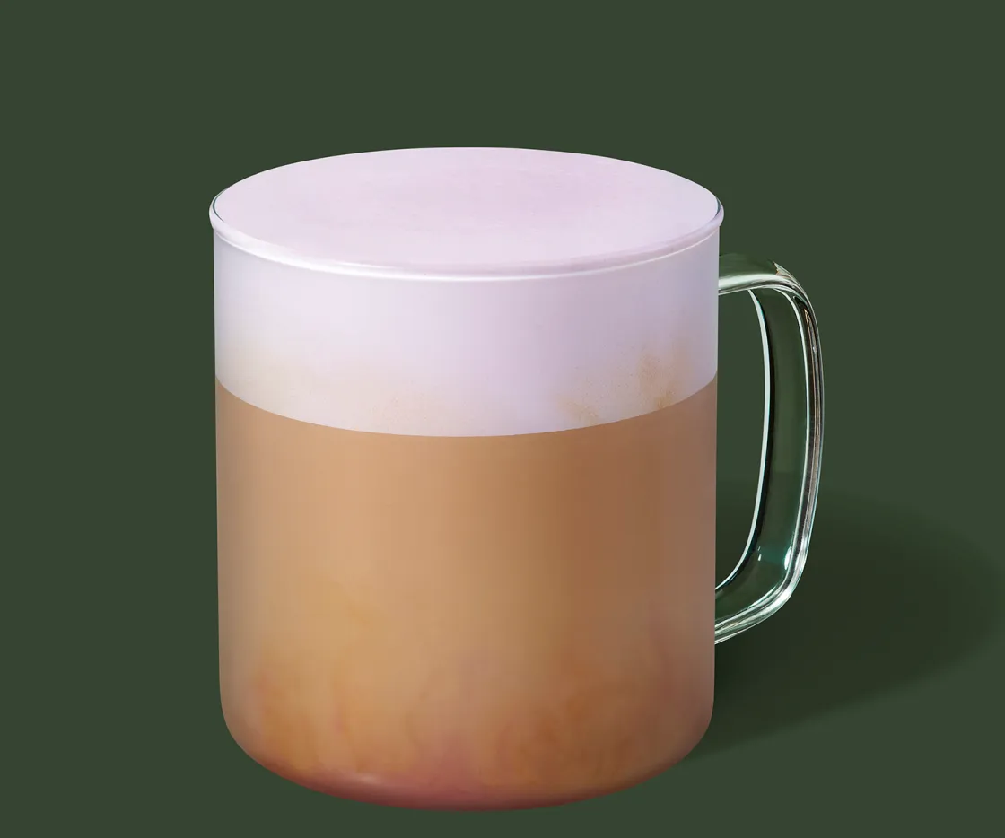 Uma chávena de Ube Vanilla Velvet Latte quente com fundo verde