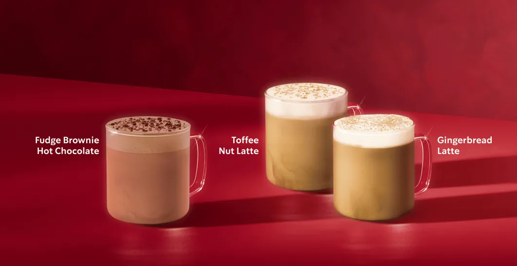 Três cafés quentes em chávenas de vidro sobre uma mesa vermelha e com um fundo vermelho