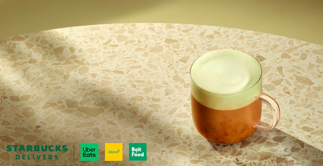 Uma chávena de vidro com café quente, sobre uma mesa